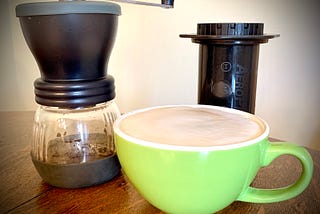 coffee grinder, aeropress, and a latte