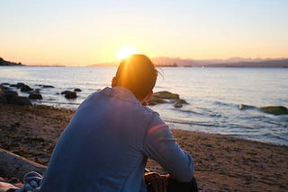 A man sitting by the water in contemplation