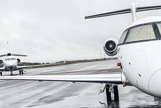 Two private jet aircraft parked on an airport tarmac.