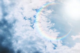 clouds with a circular sunbow (red on the inside, blue on the outside)