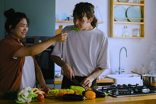 A couple cooking a meal together.