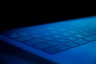 Computer keyboard faintly lit by blue light