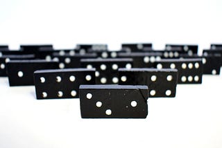 Black and white Dominos facing the camera in a pyramid formation