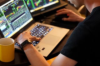 A man looking at screens with stock information