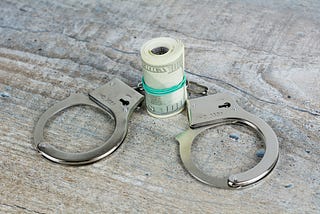 A cash bankroll and handcuffs