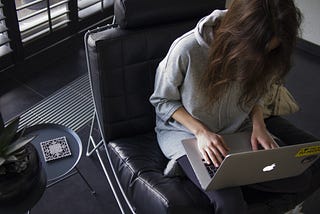 A woman writing on her laptop computer