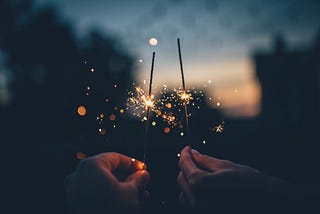 Two hands holding fireworks, in celebration of New Year