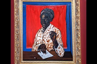 A black woman stares at us deeply as she pulls the thread off of a crimson red cloth in the background, suspended off of a barbed wire, over an even deeper royal blue plane. One hand holds a loose pearl, the other holds two pearls threaded through in the string coming from the red cloth. The pearls in the string and her hand rest on an apparently blank loose sheet of a notebook. A lone pearl rolls loose on the sheet of paper, while a last pearl hangs in the air in the foreground.