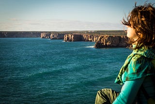 “The young woman stood on the edge of the cliff, looking out at the vast ocean below”