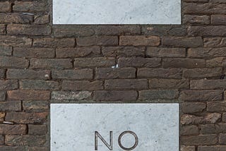 Brick wall with a sign saying Yes and a sign saying No