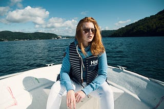 Girl with red hair, sitting in a boat