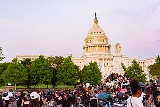 Photo of people of color and white people gathered in front of the U.S. Capitol.