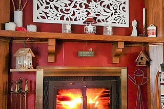 A red fireplace decorated with whimsical items on the mantel and next to it.