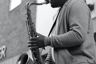 A young man playing saxophone on the street