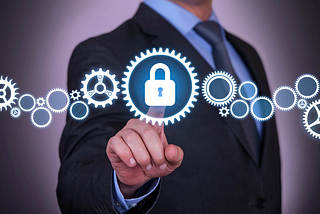 Image of a person in a suit holding pressing on padlock icon with gears around it