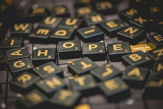 A mess of Scrabble tiles but the word Hope is visible as order in the chaos