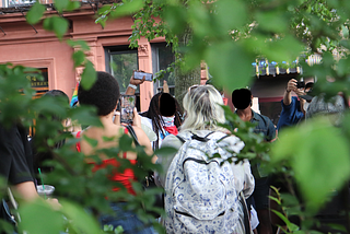Surrounded by greenery at every angle, a group of activists and protestors raise their fists in Christopher Park, Manhattan.