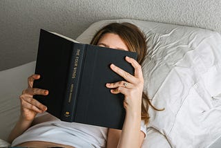 Person reading in bed.