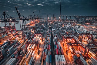 An image of a port with lots of shipping containers stacked up