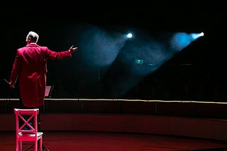 A circus ringmaster facing his audience