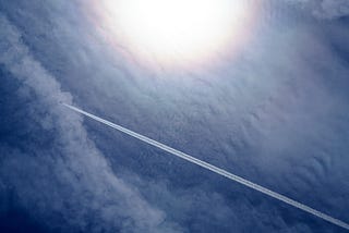 Aircraft contrails against high clouds