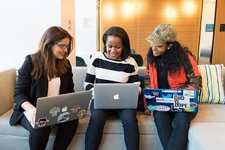 Three women working together on their laptops