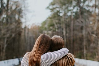 Two friends with arms around each other