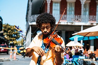 Man plays violin on street corner