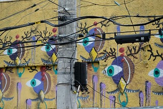 Wall mural with stylized faces with single eyes watching
