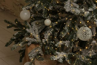 Close up of a Christmas tree with matching white bulb decorations.