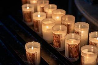 group of lit prayer candles
