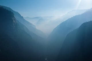 Yosemite valley. There is some mist and the mountains are a blueish hue.