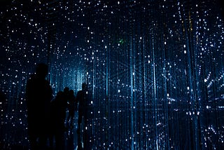 Shadowy figures in a grid of blue-white lights in a dark space