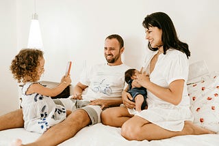 Image of a family sitting on their bed