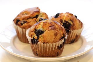 3 blueberry muffins on a white plate