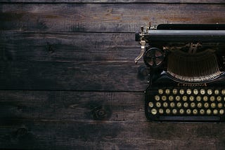 Typewriter on dark wood desk.