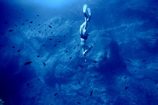 Person diving in the deep blue sea