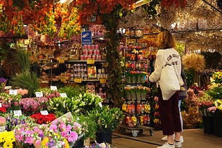 Woman in a market bursting with colorful goods