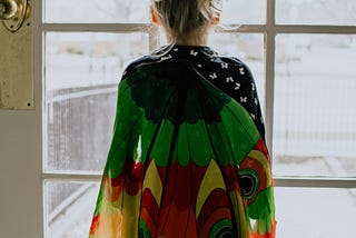 Young child in costume staring out the window.