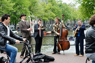 group of musicians playing music with water nearby