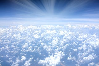 Beautiful clouds in the light blue sky with light radiating depicting the kingdom of heaven