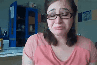 This is a GIF of Lyndsey in her apartment in Honduras crying and wiping her eyes with Kleenex while talking to the camera.