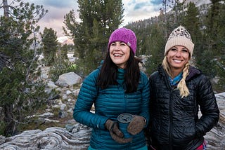 A brunette and blonde women hiking in the mountains.