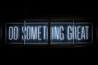 An image of neon lights saying “Do something great”