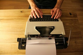 Person typing on a typewriter.