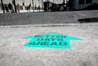 A message painted on the ground that says, “BETTER DAYS AHEAD”
