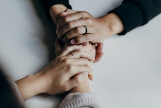 Two people holding hands across a table