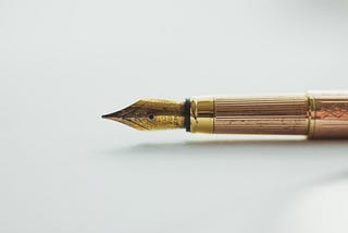 A gold fountain pen on a white background.