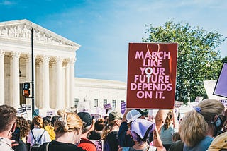 A image from a womens march with a sign that says “march like your future depends on it.”