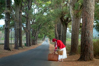 A woman carries heavy baggage.